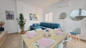 塞维利亚Apartamentos TrianaSol的客厅配有桌子和蓝色沙发