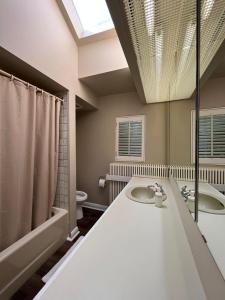 多伦多49 Hostel的一间带两个盥洗盆的浴室和一个大窗户
