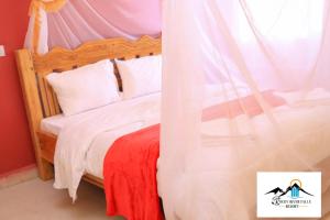 ThikaRocky river falls resort的一间卧室配有一张带天蓬的床