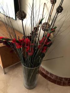 内坦亚尼茨萨海景公寓的花瓶里满是红花和棍子
