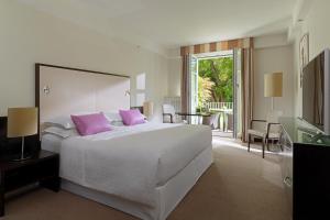 萨尔茨堡萨尔茨堡喜来登大酒店的卧室配有带粉红色枕头的大型白色床