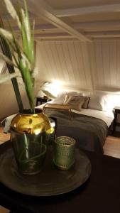哈林亨Anna's Zusje Boetiekhotel的一间卧室配有一张床和一张带花瓶的桌子