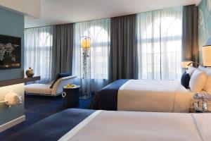 汉堡汉堡万丽酒店的酒店客房,配有两张床和椅子