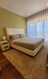 加亚新城Casa da Praia的一间卧室设有一张大床和一个大窗户