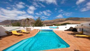 法马拉Bungalow Allende Famara con piscina privada y AC的一座带庭院的游泳池,其背景是山脉