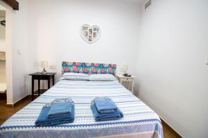莫特里尔RentitSpain Carrera del Mar, 17 Apartamento的一间卧室配有一张带蓝色毛巾的床