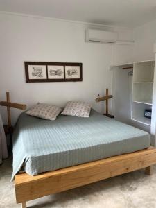 Coteau RaffinOtium的一间卧室配有一张带两个枕头的木床
