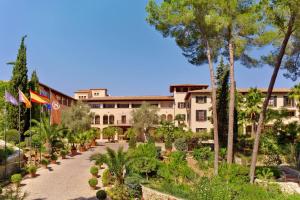 马略卡岛帕尔马Sheraton Mallorca Arabella Golf Hotel的享有树木和植物的建筑景色