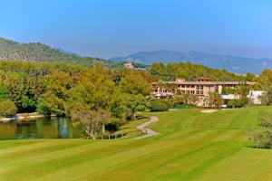 马略卡岛帕尔马Sheraton Mallorca Arabella Golf Hotel的一座带湖泊和建筑的高尔夫球场