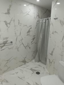 帕塔拉瓦卡Patalavaca, aguamarina的带淋浴和浴帘的白色浴室