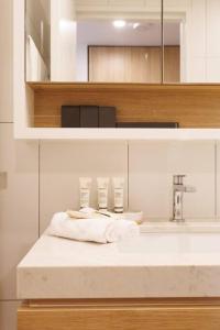 布里斯班Luxurious 2 Bed City Scape Retreat with Rooftop的浴室配有盥洗盆和带毛巾的台面。