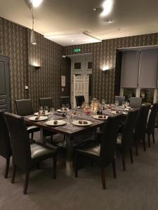 吕讷Hôtel-Restaurant-Chambre Insolite Spa - Le XII de Luynes的大型用餐室配有长桌和椅子