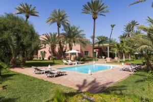 马拉喀什阿比阿德别墅的一个带躺椅和棕榈树的度假游泳池