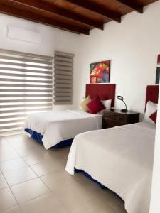 圣塞瓦斯蒂安Casa Campo Bed & Breakfast的一间卧室设有两张床和窗户。