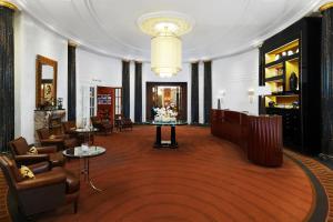 维也纳Hotel Bristol, a Luxury Collection Hotel, Vienna的酒店大堂设有桌椅和吊灯。