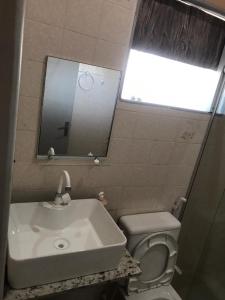 德奥多鲁元帅镇Flat à beira mar!的一间带水槽、卫生间和镜子的浴室