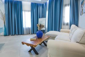 PanayíaTheoxenia Kasos Luxury Apartments的客厅配有蓝色窗帘和花瓶