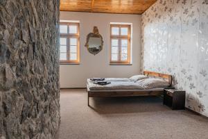 特普利采Penzion hrad Doubravka的一间卧室设有一张床和石墙