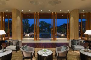 华欣华欣万豪水疗度假酒店的大堂设有桌椅和大型玻璃门