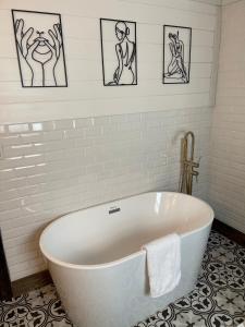 Battle GroundCasita at the Winery的浴室设有白色浴缸,墙上挂有图片