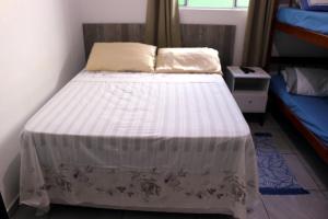 弗洛里亚诺波利斯Pousada Decarli Executiva Aeroporto Florianópolis的卧室配有带白色棉被的床