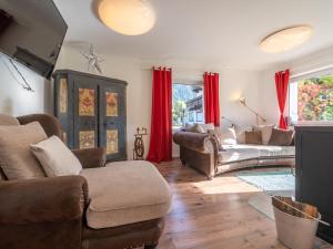 迈尔霍芬Regenbogenhaus的客厅配有皮革家具和红色窗帘