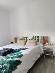 阿尔泽特河畔埃施AtHome - Appart-hotel with private parking的一间卧室配有一张带绿叶的大白色床