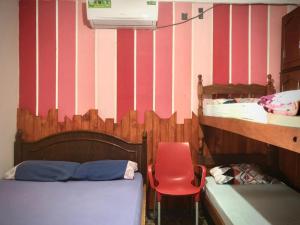 伊瓜苏港Hosteria NAMAJU的一间卧室配有一张床和一张红色椅子