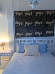 丹吉尔Havre de paix en face de l'océan的一间卧室,配有一张床,墙上挂着马匹