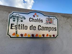 坎波斯杜若尔当Chalés Estilo de Campos的建筑物一侧的标志