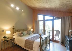 哈罗盖特Springwood Lodges的一间卧室设有一张床和一个阳台