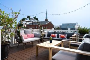 巴尔的摩Luxury Federal Hill Home with Rooftop & 4 Parking Spots的阳台的天井配有沙发和桌子。