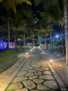 嘎林海斯港Marulhos Muro Alto, Apartamento Encantador的一条鹅卵石街道,晚上有棕榈树