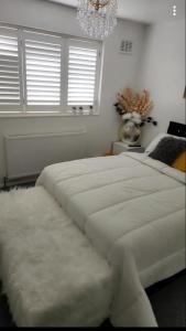 巴塞尔顿Private luxurious space的卧室配有一张带吊灯的大型白色床。