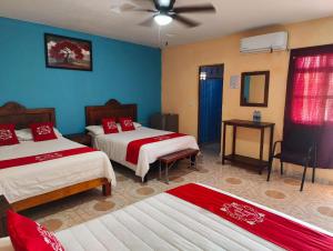 帕拉斯德拉富恩特Hotel Posada Santa Elena的一间卧室配有两张床和吊扇
