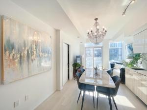 多伦多Boutique Penthouse-Live in the SKY with Amazing Lakeview! Downtown Toronto!B的一间带桌椅和吊灯的用餐室