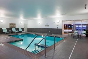 盐湖城万豪盐湖城机场春季山丘套房酒店的一座带桌椅的游泳池