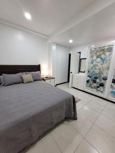 格罗斯岛Chalet Belizomi Tropical Villa #1的卧室配有一张床,墙上挂有绘画作品