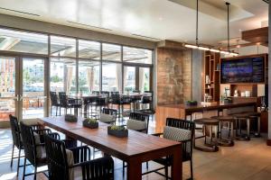 尔湾尔湾斯贝特鲁姆购物中心万豪酒店的餐厅设有木桌、椅子和窗户。