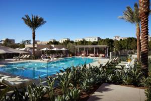 尔湾尔湾斯贝特鲁姆购物中心万豪酒店的一个带椅子和棕榈树的大型游泳池