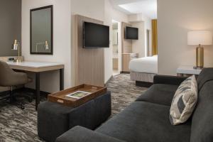 西雅图西雅图市区春山套房酒店的酒店客房设有沙发、书桌和床。