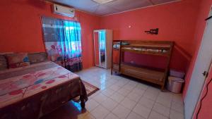 BelfastBeautiful 1-Bedroom in St Thomas Jamaica的卧室设有红色的墙壁、一张床和窗户