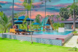 KilinochchiReecha Organic Resort Jaffna的度假村的游泳池,配有蓝色遮阳伞