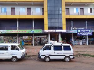 KakkabePaadi Inn的停在大楼前的两辆白色车辆