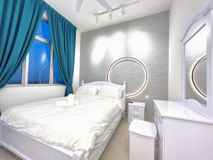 新山SKS Habitat 461 2BR 4-5pax Larkin Johor Bahru的卧室配有白色的床和蓝色窗帘