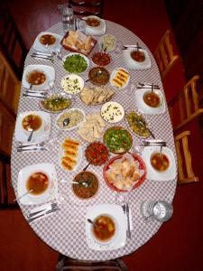 乌树故里安吉丽娜旅馆的餐桌上放有盘子和碗的食物