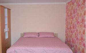 里加Julia Apartment Riga Imanta的一间卧室配有一张带粉红色床罩的床