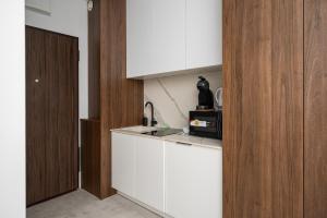 华沙Wola Pawia Modern Studio的厨房配有白色橱柜和水槽
