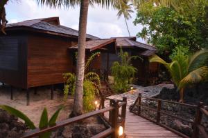 Maratua AtollNunukan Island Resort的海滩上的房子,有木路