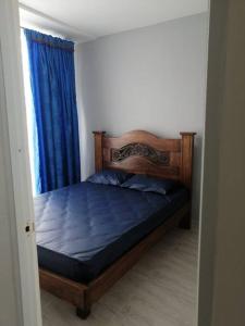 里考尔特Bellísima casa para descansar的一间卧室配有一张带蓝色床单的床和一扇窗户。